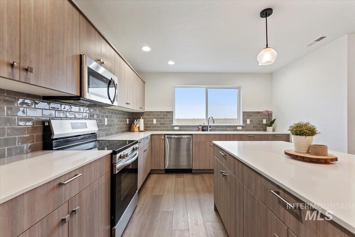 4086 North Kithnos Avenue Meridian, ID 83646 - Photo 10 of 29 Kitchen featuring stainless steel appliances, modern cabinets, pendant lighting, light wood finished floors, and recessed lighting