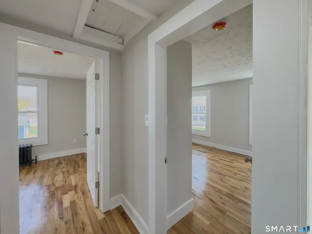 a view of hallway with wooden floor
