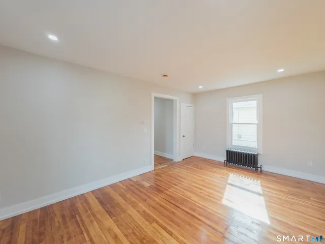 a view of an empty room with wooden floor