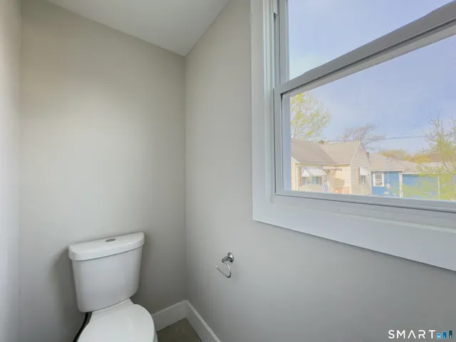 a white toilet sitting next to a window