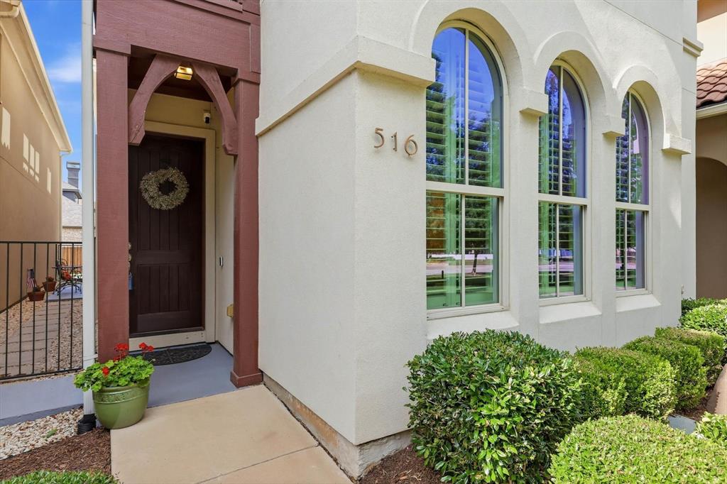 516 Sandy Lane Flower Mound, TX 75022 - Photo 5 of 38 Stucco exterior with a terracotta tile roof accent and arched windows featuring interior plantation shutters