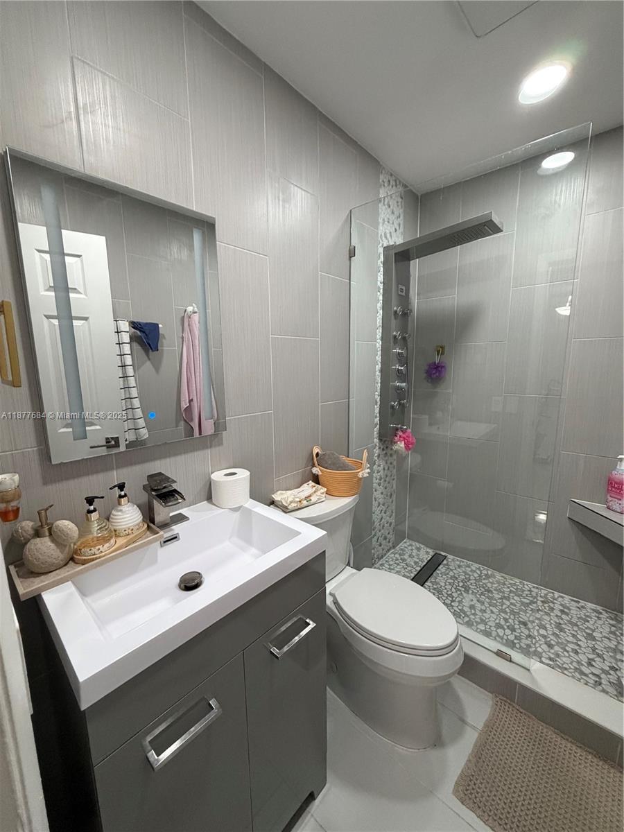 7684 Northwest 179th Street Hialeah, FL 33015 - Photo 12 of 13 a bathroom with a sink toilet vanity and shower
