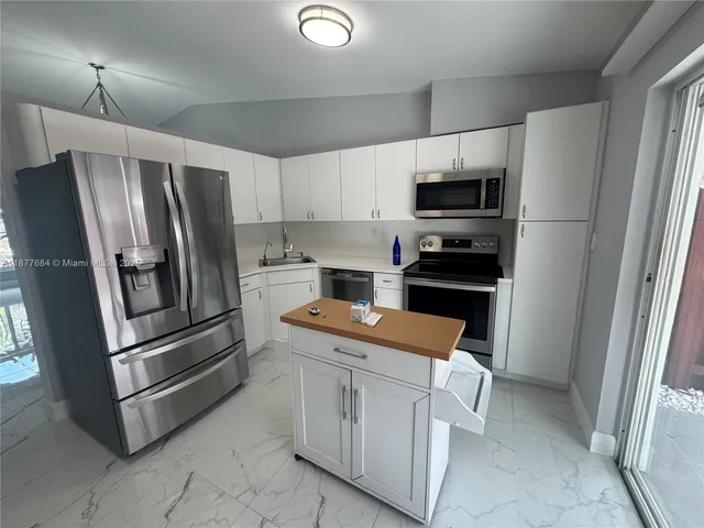 a kitchen with white cabinets and stainless steel appliances