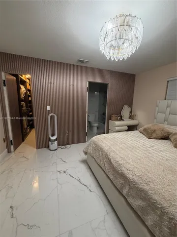 a spacious bedroom with a bed and a chandelier
