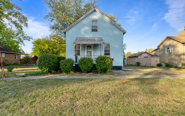a front view of house with yard and trees around