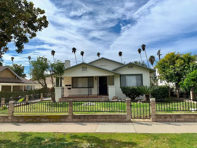 a front view of a house with a garden and plants