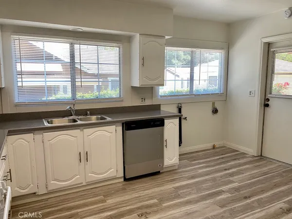 a kitchen with stainless steel appliances granite countertop a sink a stove cabinets and a window