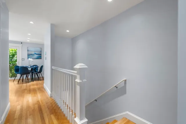 a view of a hallway with furniture and wooden floor