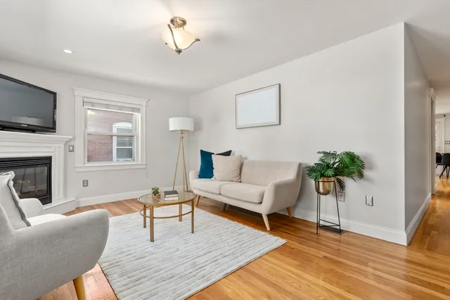 a living room with furniture a flat screen tv and a potted plant