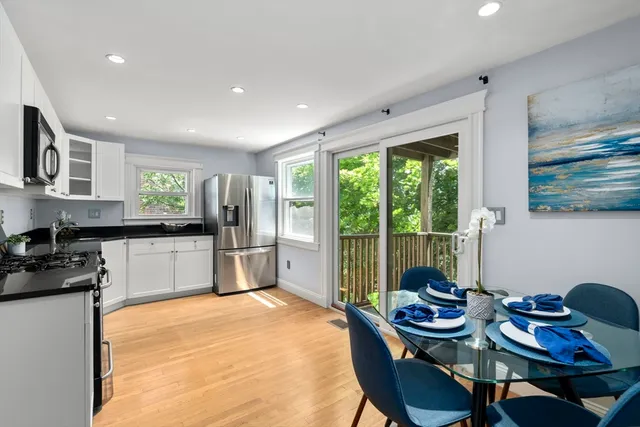 a kitchen with sink refrigerator dining table and chairs