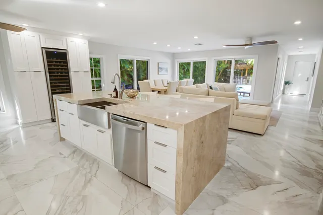 a living room with stainless steel appliances furniture and a flat screen tv