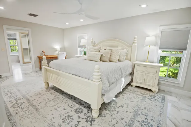 a spacious bathroom with sink a mirror a bathtub and next to a window