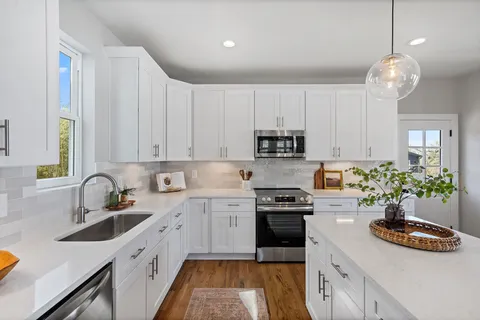 a kitchen with kitchen island granite countertop a sink stainless steel appliances and cabinets