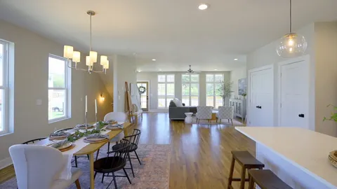 a view of a dining room and livingroom with furniture wooden floor a chandelier