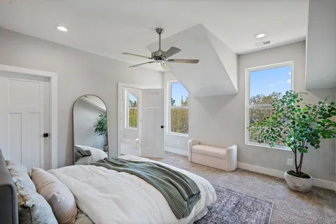 a spacious bedroom with a balcony a bed and a chandelier