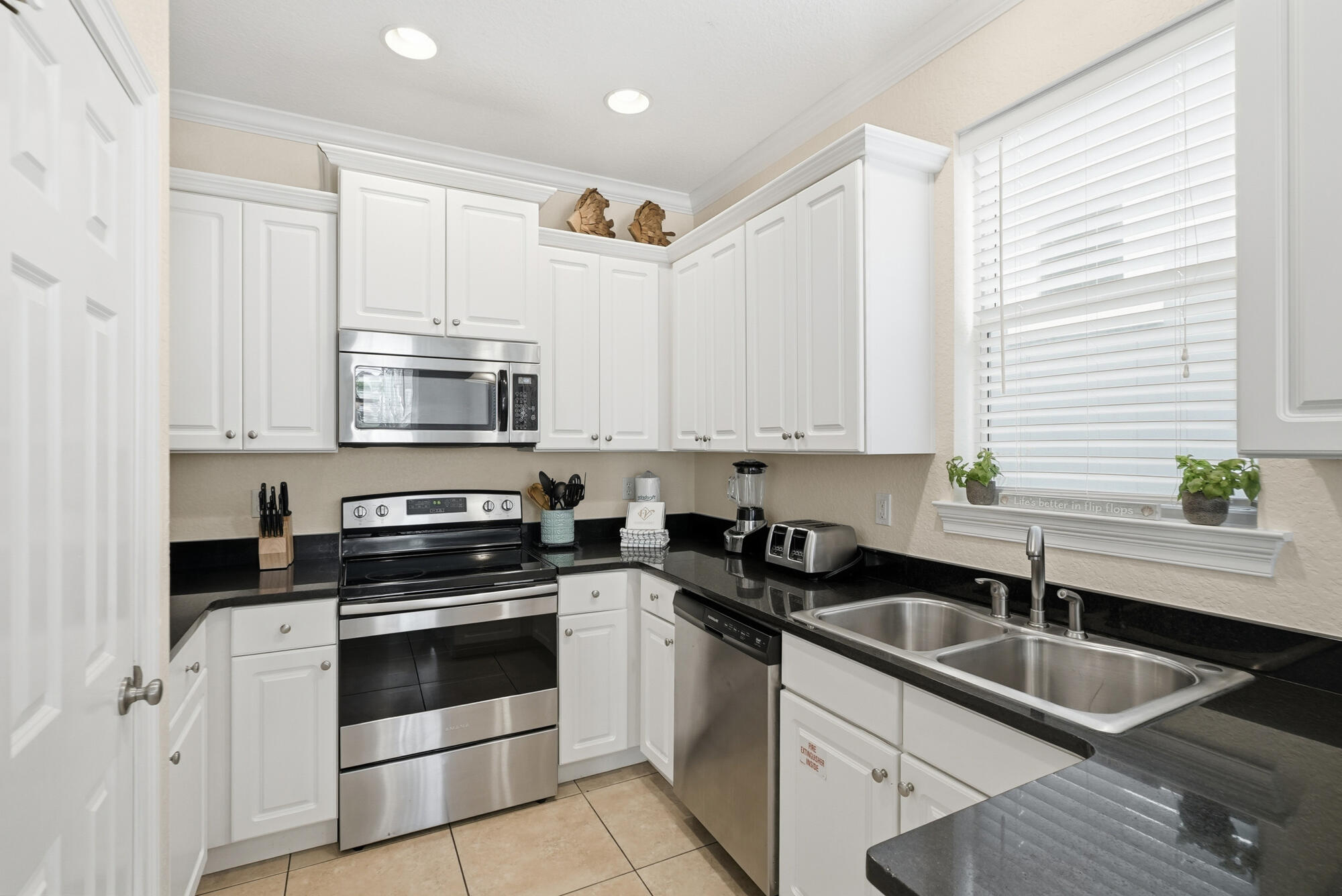 231 Kono Way Destin, FL 32541 - Photo 11 of 41 a kitchen with granite countertop a sink a stove and cabinets