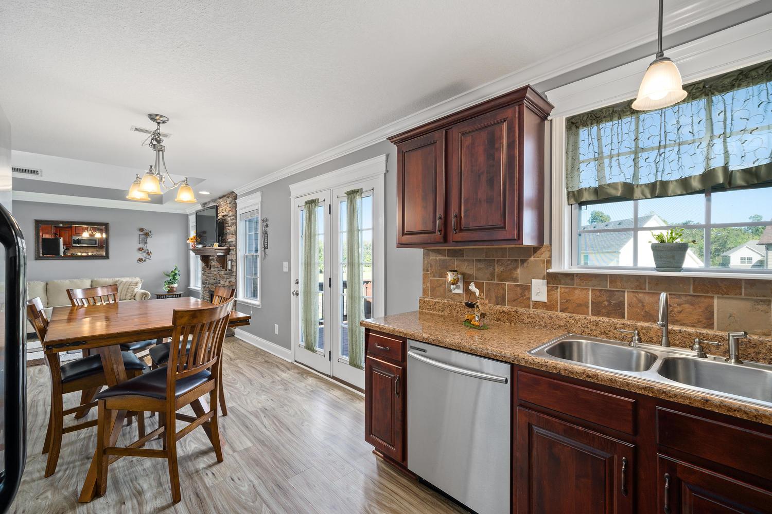 3803 Suiter Road Clarksville, TN 37040 - Photo 8 of 28 a kitchen with stainless steel appliances granite countertop wooden cabinets a dining table and chairs