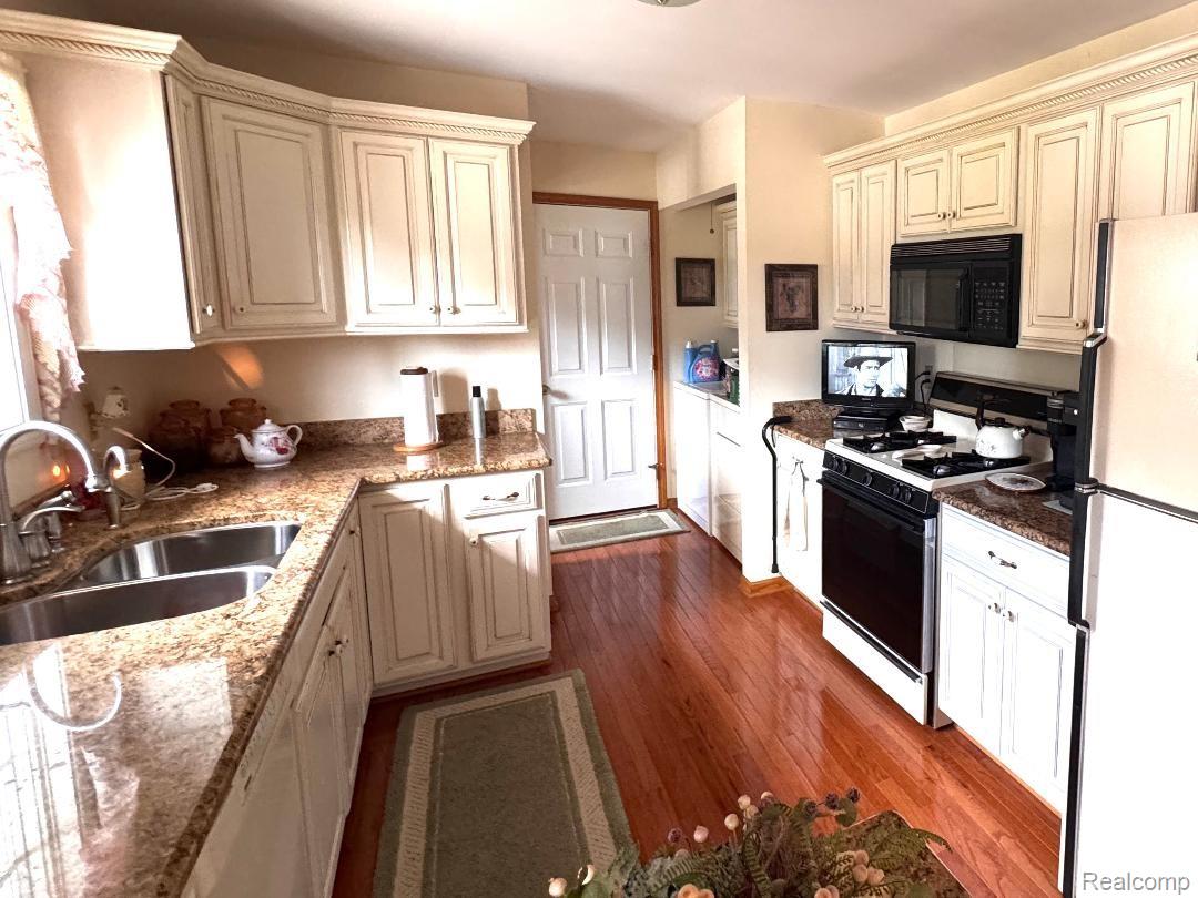6686 South Schott Road Mayville, MI 48744 - Photo 4 of 25 Kitchen featuring perimeter cabinetry with crown molding, granite countertops.