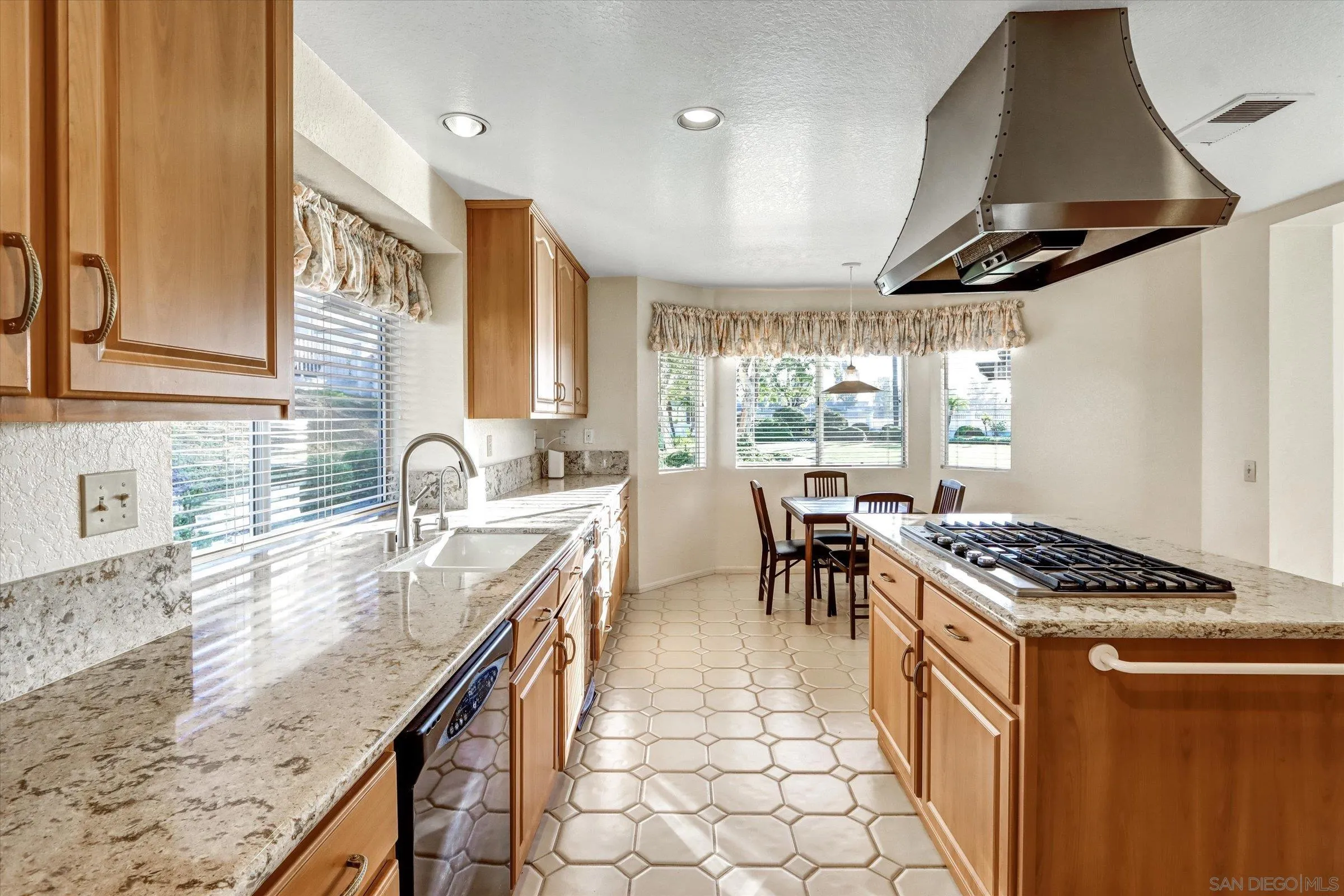 1840 Cabernet Drive Chula Vista, CA 91913 - Photo 17 of 66 a kitchen with granite countertop a stove a sink a dining table and chairs