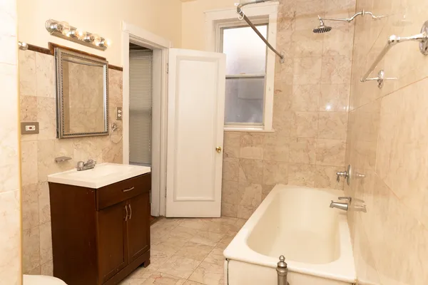 a bathroom with a sink vanity tub and a mirror