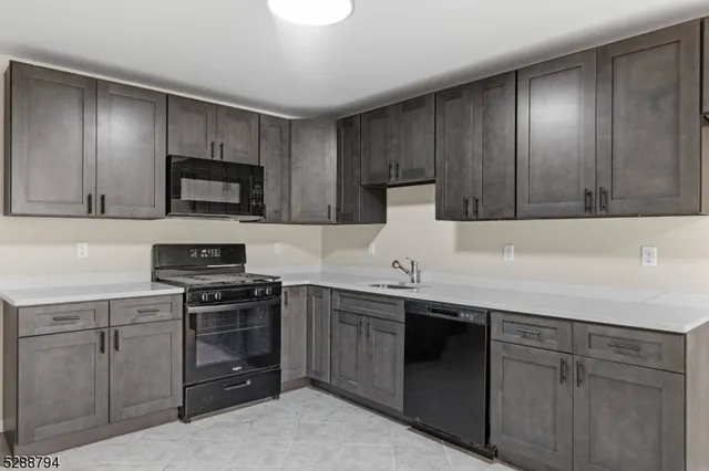 a kitchen with cabinets stainless steel appliances and a sink