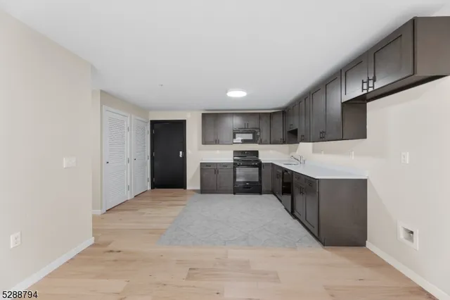 a large kitchen with a large counter top stainless steel appliances and cabinets