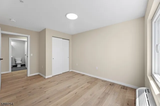 an empty room with wooden floor and a window