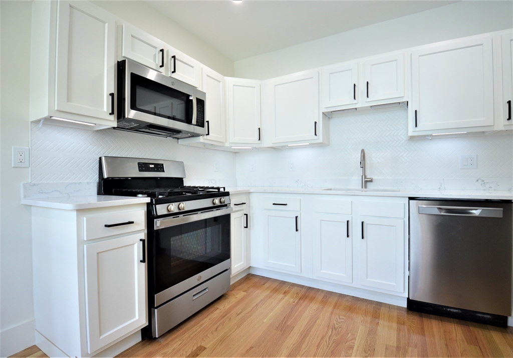 27 Ransom Road, Unit 2 Boston, MA 02135 - Photo 2 of 29 a kitchen with stainless steel appliances white cabinets granite counter tops and a hard wood floors