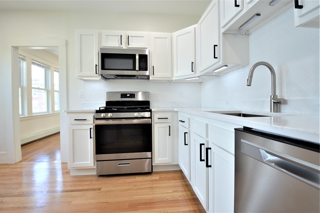 27 Ransom Road, Unit 2 Boston, MA 02135 - Photo 3 of 29 a kitchen with stainless steel appliances a stove a microwave and sink