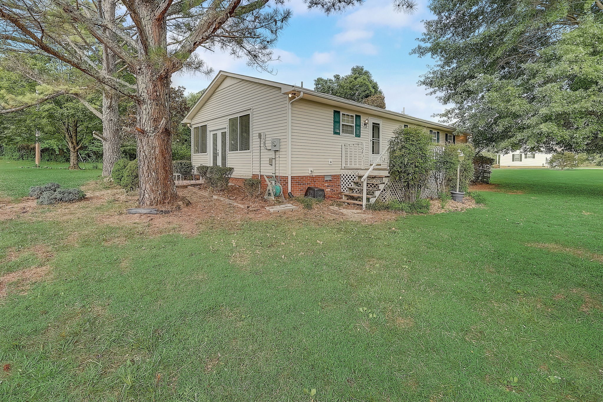 356 Howard Redmon Road Sparta, TN 38583 - Photo 45 of 68 a backyard of a house with table and chairs and large trees