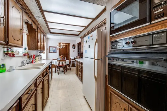 a kitchen with sink a stove and chairs
