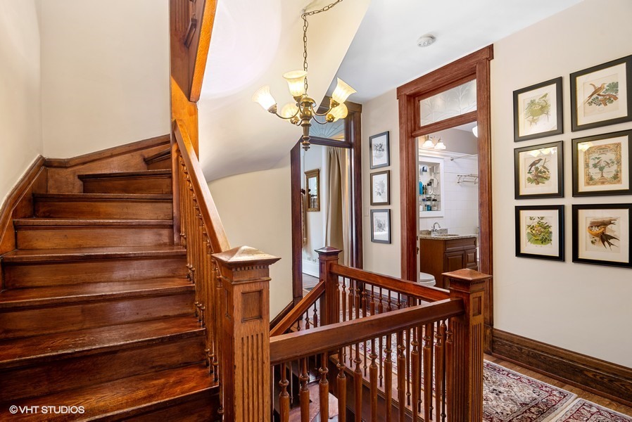 4050 North Kenmore Avenue Chicago, IL 60613 - Photo 14 of 32 a view of staircase with railing and a chandelier