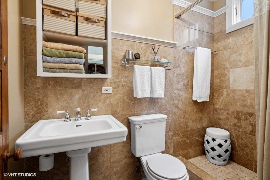 4050 North Kenmore Avenue Chicago, IL 60613 - Photo 22 of 32 a bathroom with a sink and mirror with toilet