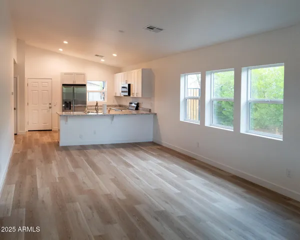 a kitchen with granite countertop a refrigerator stove and sink