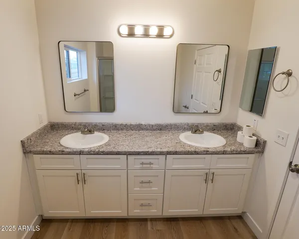 a bathroom with a granite countertop toilet sink and mirror