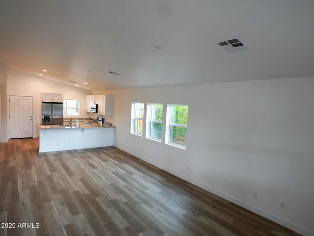 a view of kitchen with granite countertop cabinets and refrigerator
