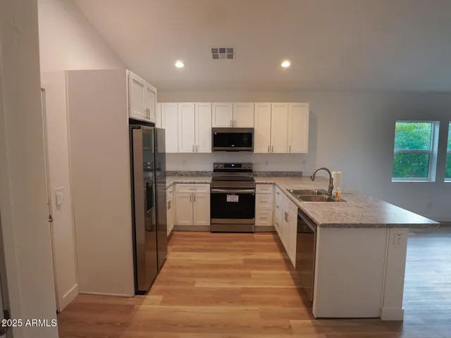 a kitchen with stainless steel appliances granite countertop a refrigerator and a stove top oven