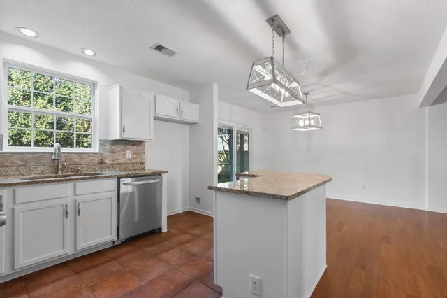 a kitchen with granite countertop stainless steel appliances a sink stove and refrigerator
