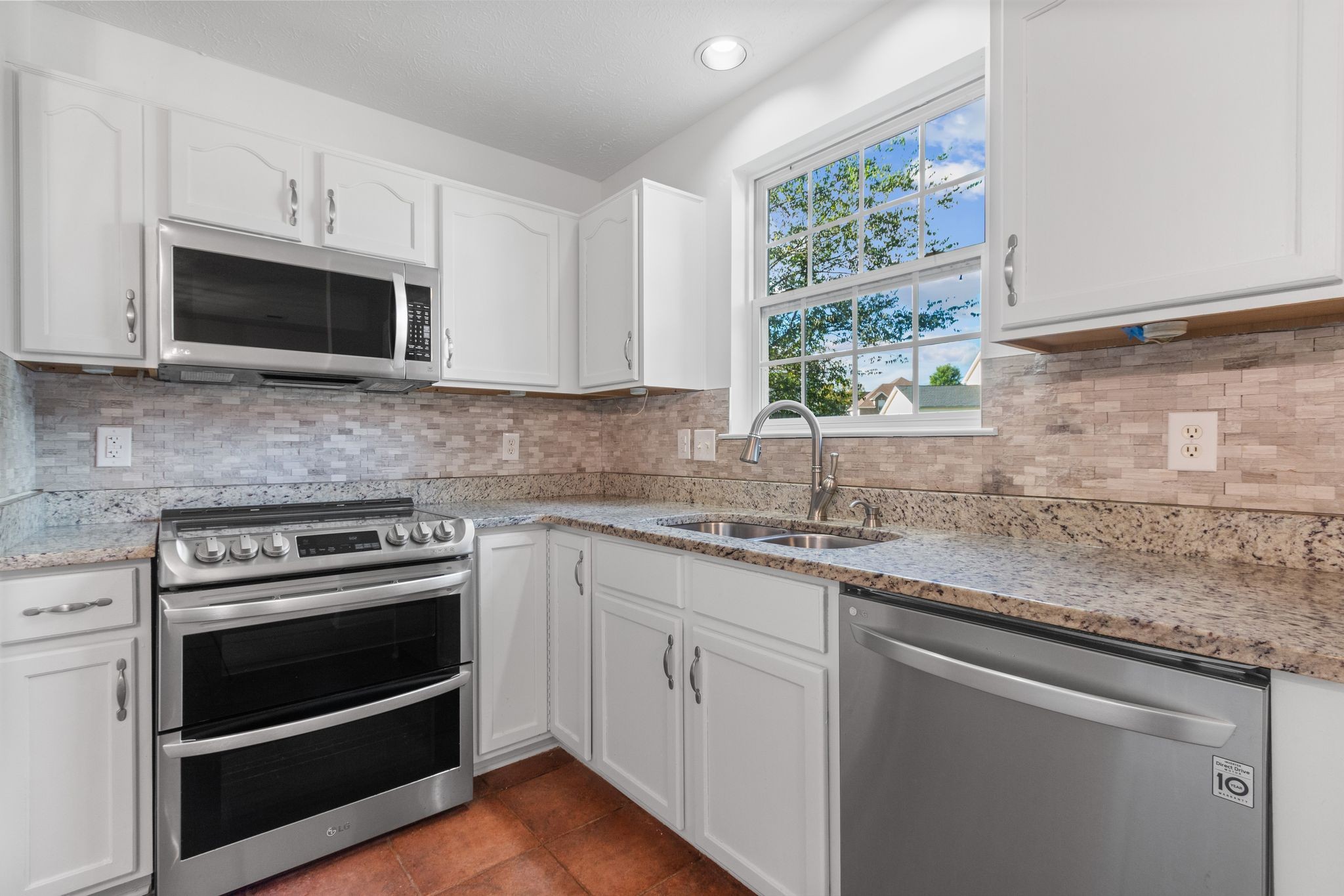 1413 Carmack Lane Spring Hill, TN 37174 - Photo 15 of 35 a kitchen with stainless steel appliances granite countertop white cabinets granite counter tops and a window