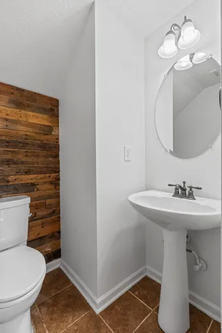 a bathroom with a sink a toilet and mirror