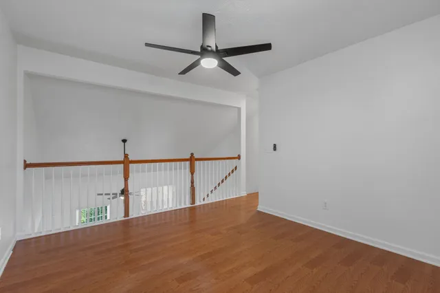 a view of a hallway with a ceiling fan