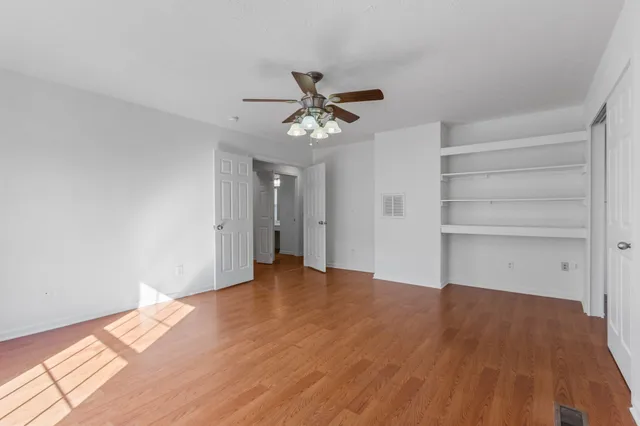 a view of an empty room with a chandelier fan