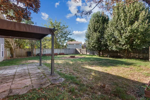 a view of a house with backyard and a tree