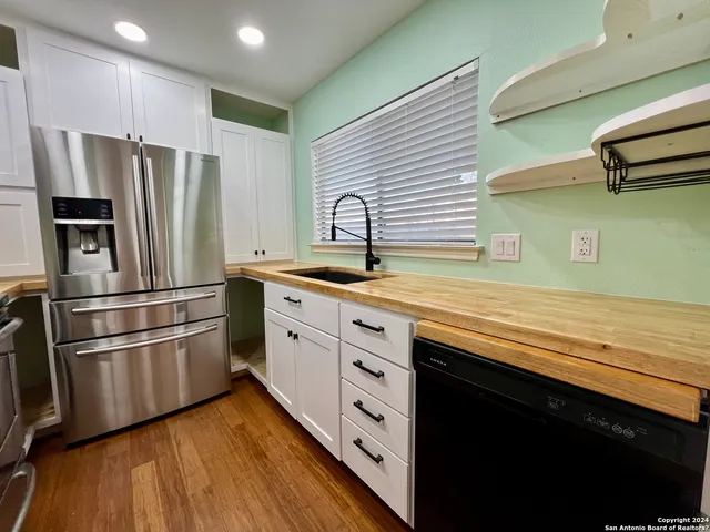 a kitchen with stainless steel appliances a refrigerator sink and cabinets