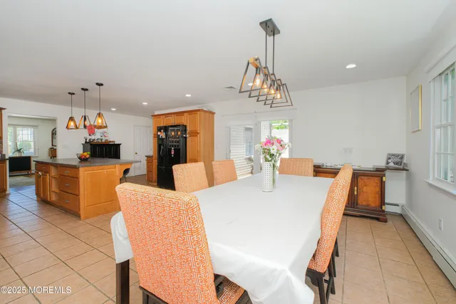 a view of a dining room and livingroom with furniture wooden floor a chandelier