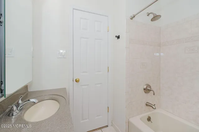 a bathroom with a granite countertop sink a toilet and shower