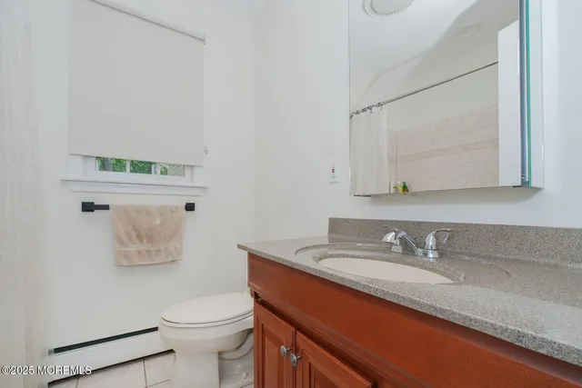 a bathroom with a granite countertop sink a mirror and a toilet