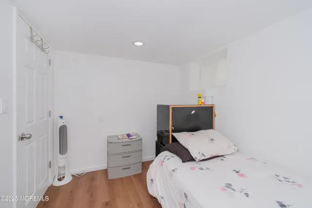 a bedroom with a bed and wooden floor