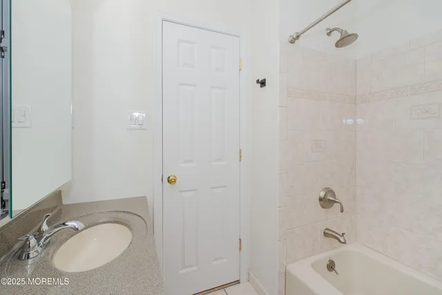 a bathroom with a granite countertop sink a toilet and shower