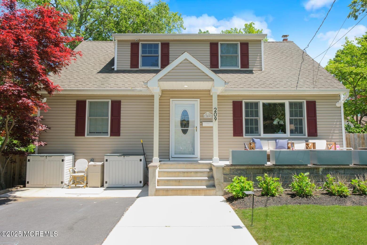 209 Woodcrest Road Oakhurst, NJ 07755 - Photo 3 of 45 a front view of a house with a garden and plants